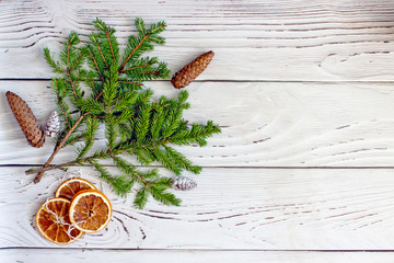 Fir branches and cones Christmas composition on a wooden background, top view, copy space. Christmas background frame with pine cones and Christmas tree branches, Dried oranges