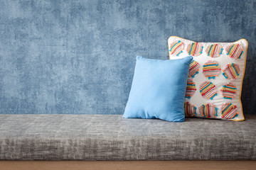 relaxing corner at home, gray cushion with pillows on blue background