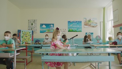 Cheerful young students with bags entering the classroom and wearing protective masks during covid-19 period. Back to school after Coronavirus. - Powered by Adobe