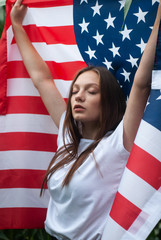 The girl with the American flag outdoors, the location is a cornfield,