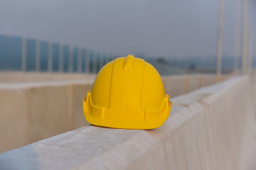 Safety helmet, yellow, blue and orange, placed on the cement floor in the construction site.