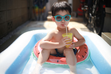 プールで飲み物を飲む男の子