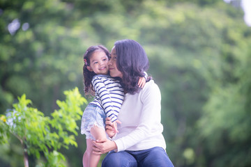 Fototapeta premium Portrait of happy loving mother and her baby outdoors, Asian girl lifestyle. Asia mother's day concept