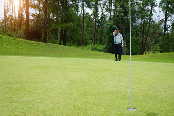 Blurred golfer playing golf in the evening golf course, on sun set evening time. Man playing golf...