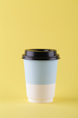 take away paper cup for coffee or tea on yellow background