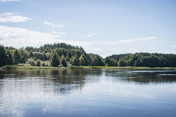peaceful river landscape, green forest reflected in the water,