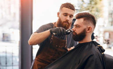 Barber working with customer in salon