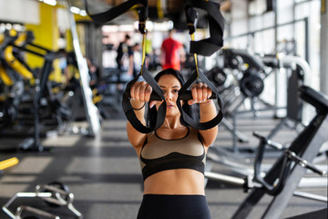 Fototapeta na wymiar Fit woman exercise on machine in gym to make a beautiful body shape
