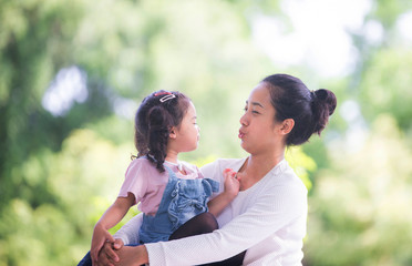 Portrait of happy loving mother and her baby outdoors, Asian girl lifestyle. Asia mother's day concept