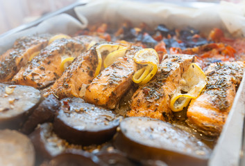 Baked salmon with vegetables on a baking sheet. Home kitchen.