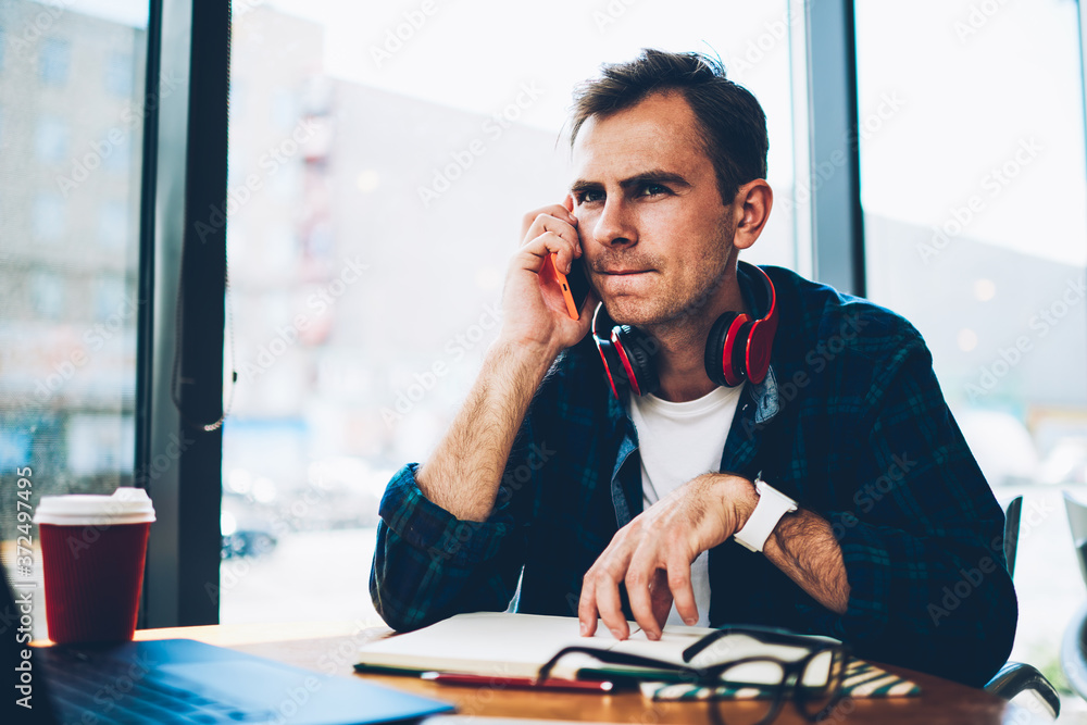 Poster pondering handsome intelligent it developer having mobile conversation with friends via application 