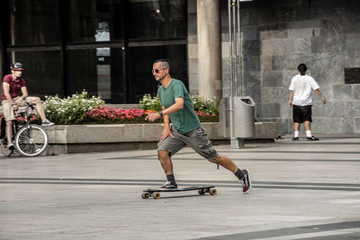 Fototapeta premium Man with mohawk hair riding on the skateboard. Cologne, Germany