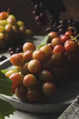 Composition with grape and towel on gray background