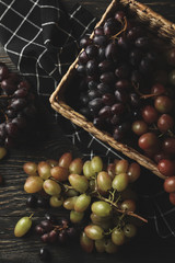 Basket with ripe grape on wooden background