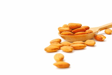 group of brown almond seed high vitamin on wooden spoon isolate on white background.