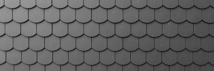 Fragment of a black roof of a private house made of shingles