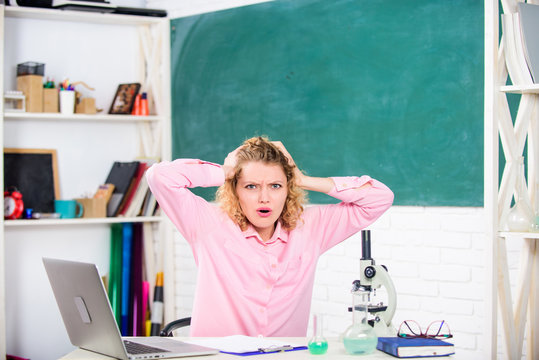 Emotional people concept. Woman tutor or student at desk with laptop and school equipment stationery. Emotional control. Emotional female teacher educator in classroom chalkboard background
