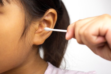 Little girl use cotton bud for cleaning ear