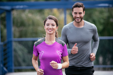 Obraz premium Athletic couple jogging in the city. Happy couple training outdoors.
