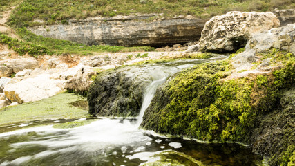 Arroyo discurre entre rocas rápidamente a su desembocadura.