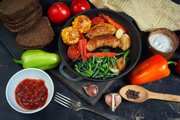 fried homemade sausages with vegetables on a plate .cooking at home . the view from the top