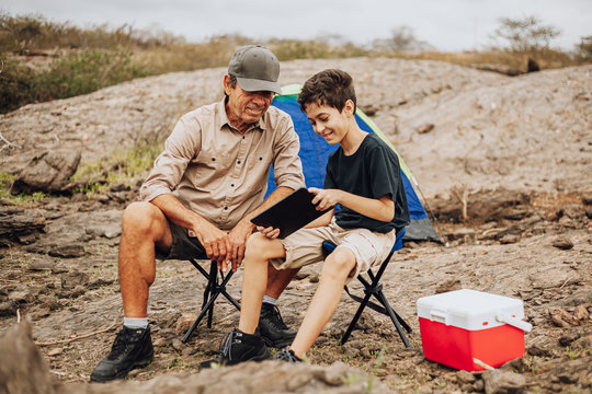 Latin grandfather and grandson camping. Concept of grandparents and grandchildren in outdoor activities.