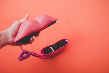 vintage pink mouth-shaped phone with orange background