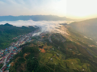 Aerial view of panorama landscape at the hill town in Sapa city, Vietnam with the sunny light and sunset, mountain view in the clouds