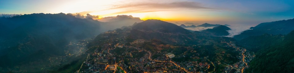 Fototapeta na wymiar Aerial view of panorama landscape at the hill town in Sapa city, Vietnam with the sunny light and sunset, mountain view in the clouds