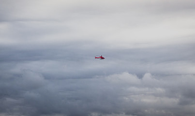 Red Helicopter in Cloudy Sky