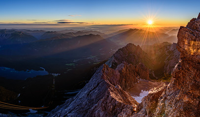 A beautiful and colorful sunrise on the summit of the highest mountain in Germany, Zugspitze at...