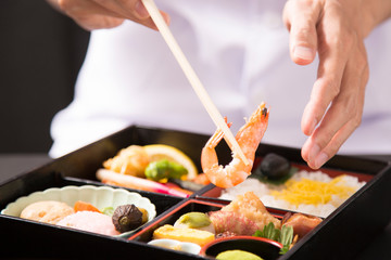 懐石弁当の盛り付けをする手元