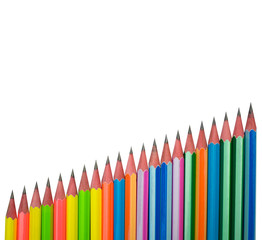 A line of different colored wood pencil crayons placed on a white paper background