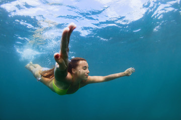 Obraz na płótnie Canvas Happy family - active teenage girl jump and dive underwater in tropical coral reef pool. Travel lifestyle, water sport, snorkeling adventure. Swimming lessons on summer sea beach vacation with kids