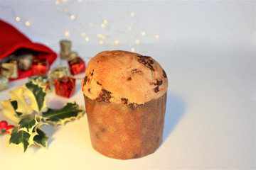Christmas greeting card. Italian Christmas sweet (panettone) with holly branch on white background.