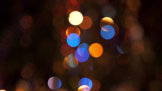 Beautiful blurred glowing blinking Christmas garland on the New Year tree. Holiday festive dynamic background