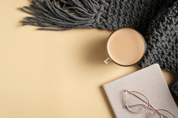 Autumn flat lay composition. Top view knitted scarf, coffee cup, glasses, paper notebook. Autumn...