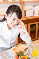 食事しながら電話をする女性