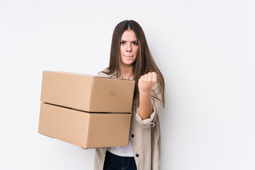 Young caucasian woman moving to a new home showing fist to camera, aggressive facial expression.