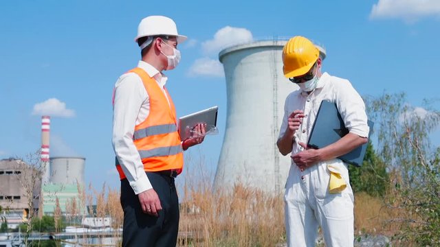 Masked workers conversation on power station. Successful enterprises are at the heart of any strategy to create employment, improve living standards. Impact crisis on global thermal power plant market