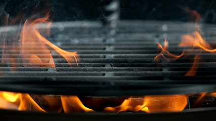 Empty flaming cast iron grate charcoal grill with open fire, ready for product placement.