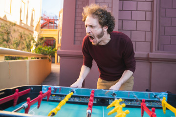 Young man playing table football.