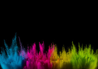 Colored powder explosion on black background. Freeze motion.