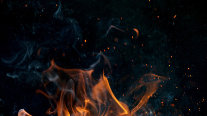Feuerflammen mit Funken auf schwarzem Hintergrund, Nahaufnahme