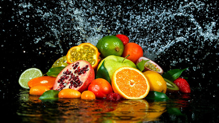 Freeze Motion Shot of Fresh Fruits with Splashing Water Isolated on Black Background.
