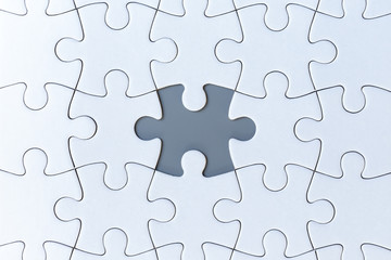 Fototapeta premium White jigsaw puzzle pieces on gray background