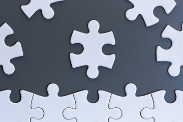 White jigsaw puzzle pieces on gray background