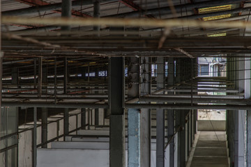 The structure inside the warehouse with light pole. Old structure in old building indoor. No focus, specifically.
