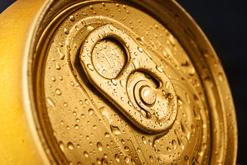 Closed tin can, close-up top view. Golden color, water drops on the bank.
