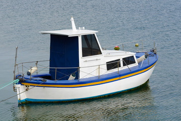 white fishing motor boat anchored in the sea